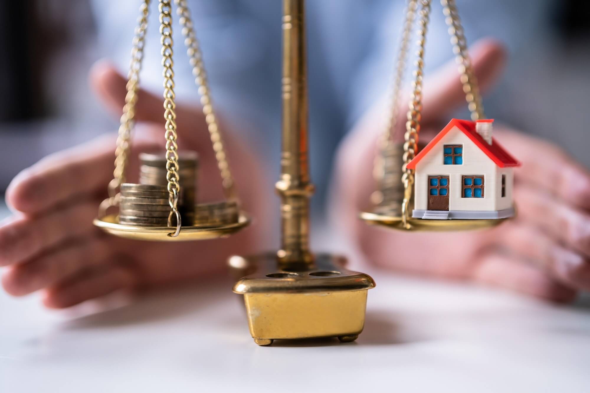 House and money on the scale when dividing assets during divorce.