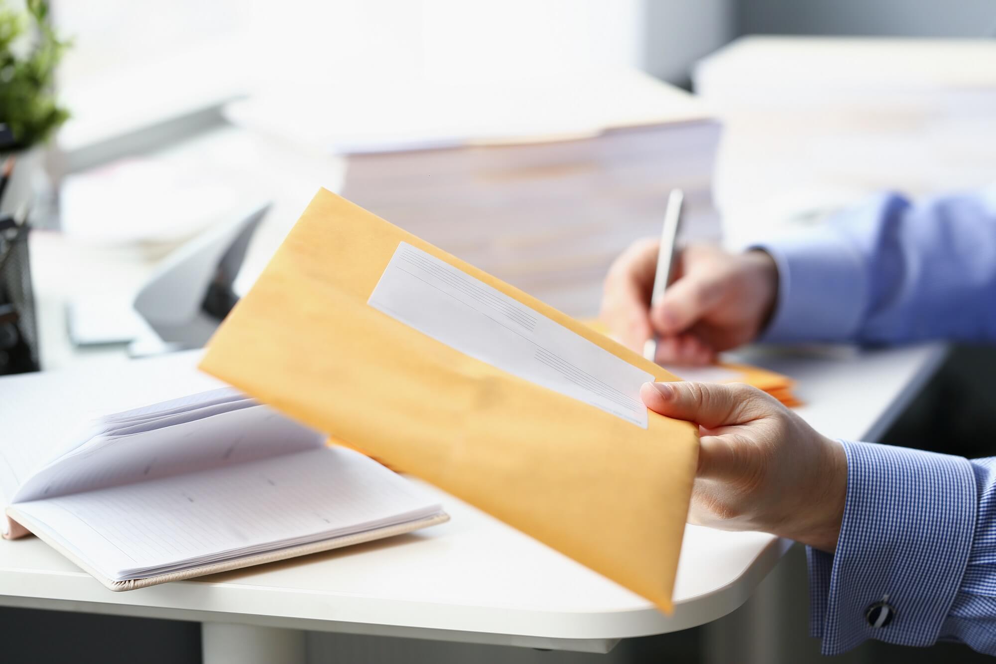 A man holds an envelope containing divorce papers from his wife.